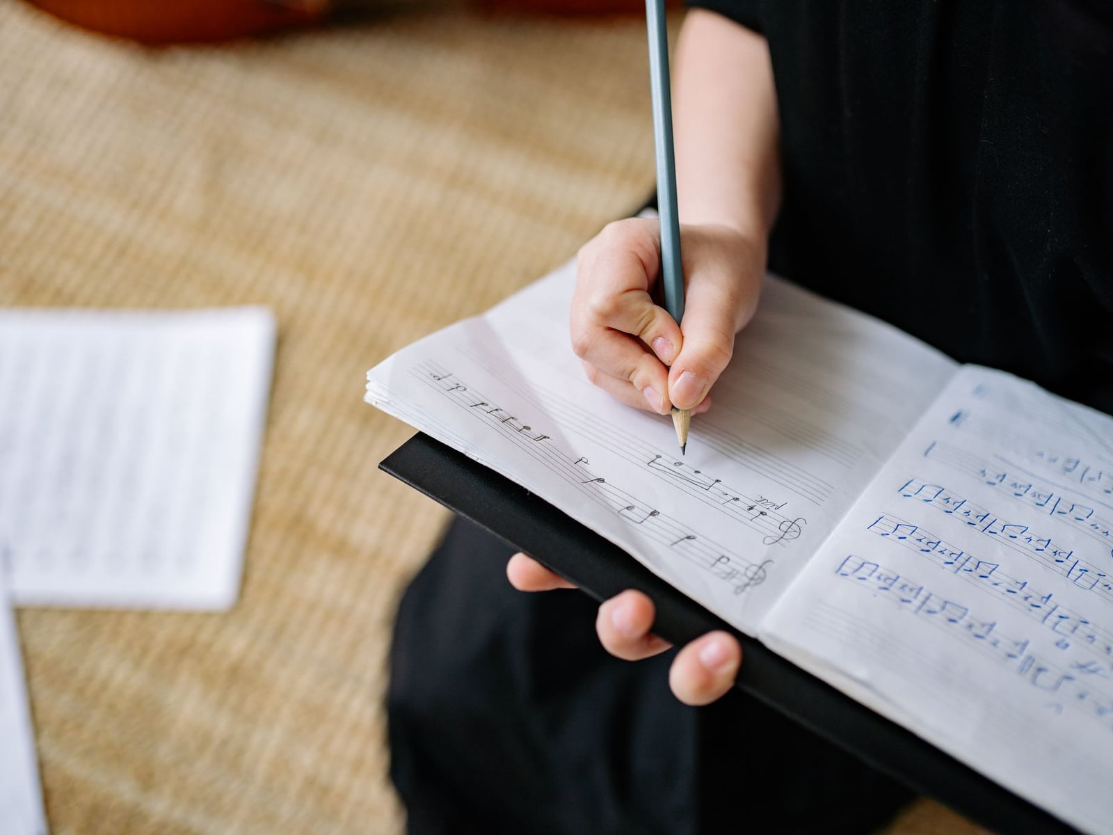 歌詞が書かれたノートとギターピックが置かれた準備中のテーブル